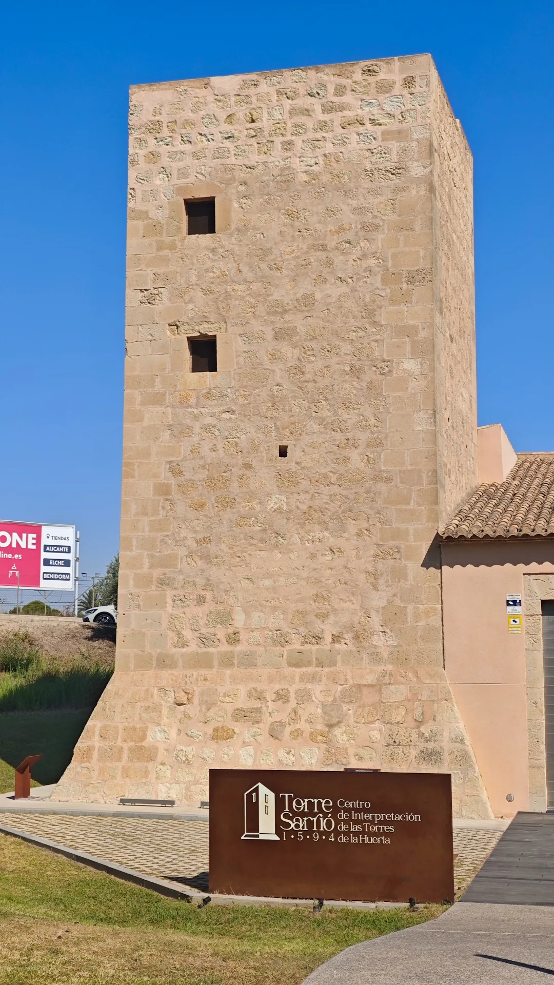 Facciata frontale della Torre Sarrió: base a scarpa, pietra da taglio agli angoli e feritoie